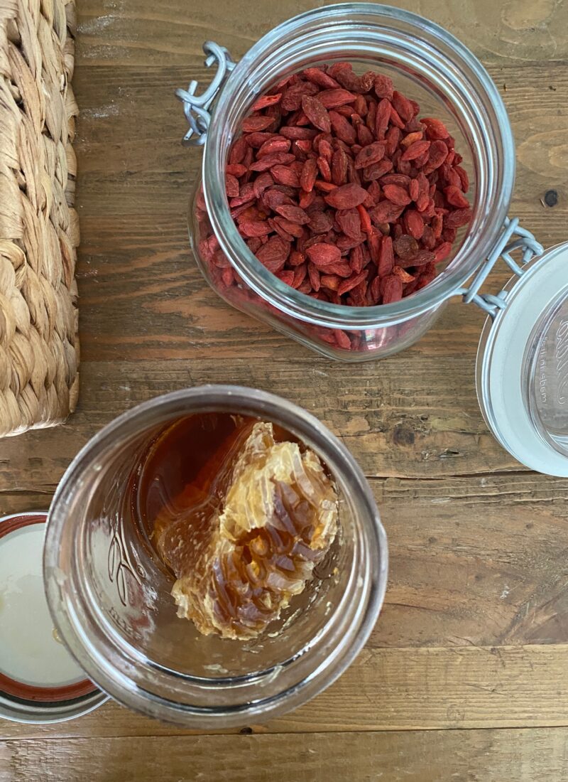 jar of honey with honey comb and jar of goji berries